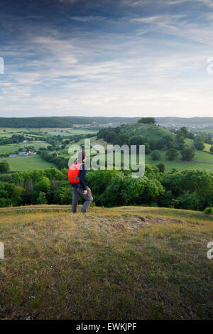 Walker su Uley Bury, guardando la vista verso Downham Hill. Il Cotswolds. Gloucestershire. Regno Unito. Una breve deviazione dal Cotsw Foto Stock