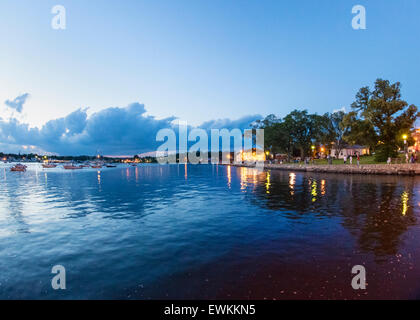 Port Washington, New York, Stati Uniti d'America. Il 26 giugno 2015. Lungo il litorale di Manhasset Bay, a destra della vista è waterside Sunset Park con luminose John Philips Sousa Memorial Band Shell durante un concerto, nel North Shore villaggio sull'Isola Lunga Gold Coast. Credito: Ann e Parry/Alamy Live News Foto Stock