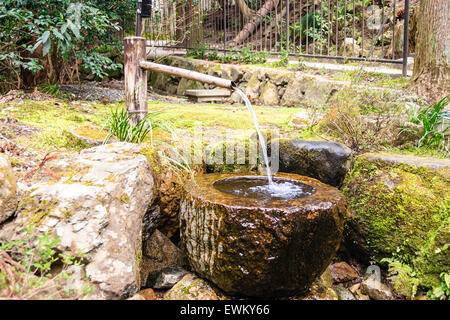 Giappone, Kyoto, Ohara. Famoso Tempio Sanzen con giardino giapponese. Kakei  fontana. Tubo di bambù con acqua che scorre in una grande ciotola di pietra  Foto stock - Alamy
