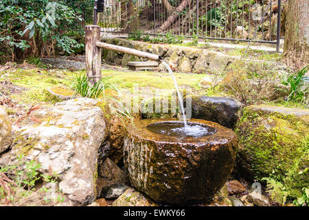 Fontana di bambù Zen che scorre in una ciotola di pietra. Fontana Zen  giapponese Foto stock - Alamy