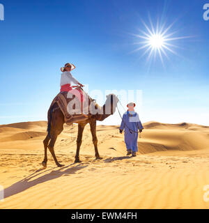 Turisti in giro in cammello, Erg Chebbi deserto vicino a Merzouga, dune del Sahara, Marocco Foto Stock