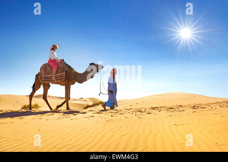 Turisti in giro in cammello, Erg Chebbi deserto vicino a Merzouga, Sahara, Marocco Foto Stock