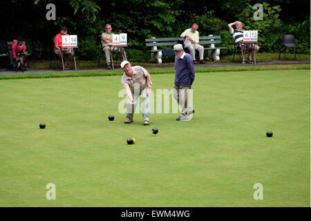 I maschi a giocare a bocce su una corona Bowling Green, la partita si è giocata nel Queens Park, Bolton, Lancashire, Greater Manchester, Inghilterra UK. fotografia DON TONGE Foto Stock