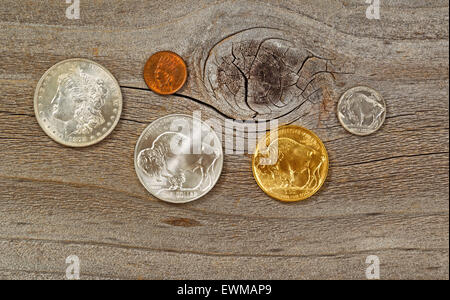 United States Mint rilasciato American vintage monete, costituito da argento, oro e nichel metallici, in legno rustico. Foto Stock