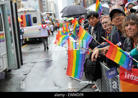 Toronto, Canada. Il 28 giugno 2015. Toronto Pride Parade watchers in attesa lungo il percorso della parata sotto la pioggia nel centro cittadino di Toronto. Credito: EXImages/Alamy Live News Foto Stock