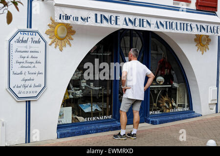 Uomo che guarda una vetrina di un negozio di antiquariato di Saint-Jean-de-Luz (Donibane Lohizune). La Francia. Foto Stock