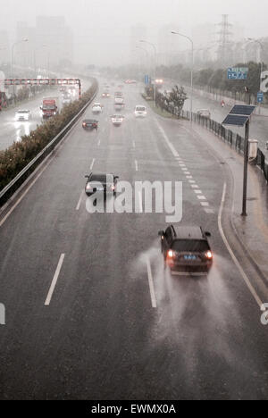 (150629) -- Pechino, 29 giugno 2015 (Xinhua) -- le automobili corrono su una strada sotto la pioggia a Pechino Capitale della Cina, 29 giugno 2015. Pechino ha testimoniato il tuono doccia meteo il lunedì e il locale ufficio meteorologico ha emesso un avviso di colore giallo per tuoni e fulmini. (Xinhua/Zheng Huansong)(wjq) Foto Stock