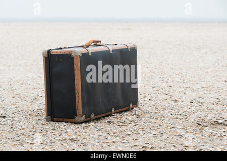 Vecchio usato vintage leather valigia per viaggiare sulla spiaggia sabbiosa Foto Stock