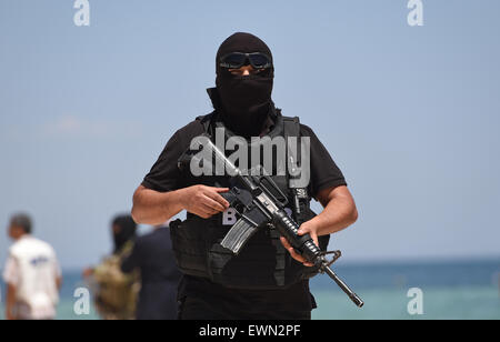 Sousse, Tunisa. Il 29 giugno, 2015. Un tunisino funzionario di polizia pattuglia durante la visita di diverse comunità il Ministro degli Interni della scena della ripresa di fronte all'Hotel Imperial Marhaba a Sousse, Tunisa, 29 giugno 2015. Almeno 38 persone hanno perso la vita in un attacco terroristico in Tunisia, soprattutto i vacanzieri. Credito: dpa picture alliance/Alamy Live News Foto Stock