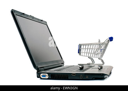 Shopping online . Piccolo carrello sul computer portatile. Isolato su bianco Foto Stock