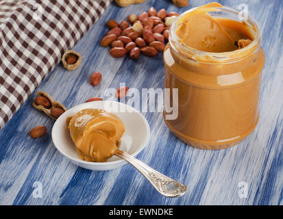 Burro di arachidi in cucchiaio con arachidi. Dof poco profondo. Foto Stock