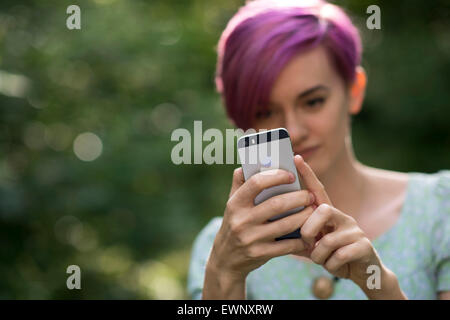 Una ragazza utilizzando un Apple iPhone per scattare una foto. Foto Stock