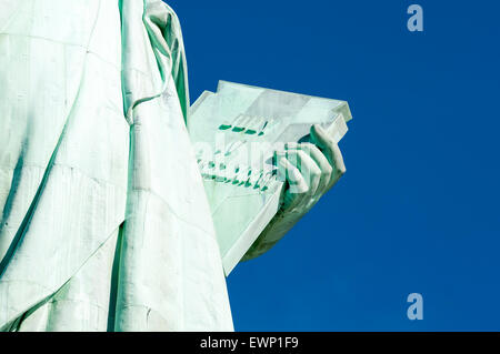 Luglio 4, 1776 Giorno di Indipendenza tablet detenute dalla Statua della Libertà di close-up contro il luminoso cielo blu Foto Stock