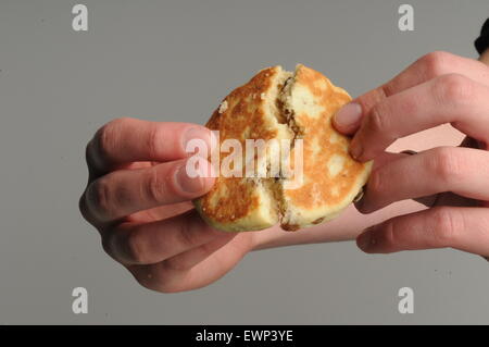 Le mani la rottura di un welshcake a metà. Foto Stock