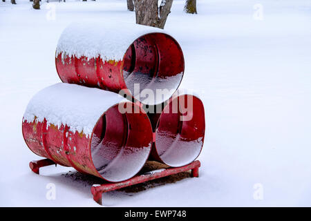 Tre rossi di barili saldate insieme per salire in un parco giochi per bambini. Inverno, la neve. Foto Stock