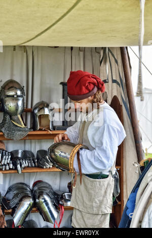 DEURNE, Belgio-Giugno 13, 2015: Unidentified partecipante del mercato medievale ricostruzioni casques prepara e altri armor di k Foto Stock