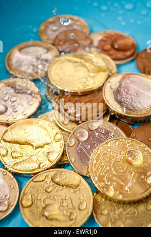 Costo di acqua con valuta Euro monete e gocce d'acqua, verticale studio shot Foto Stock