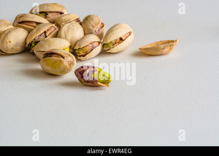 Un gruppo di pistacchi, uno è senza il suo guscio Foto Stock