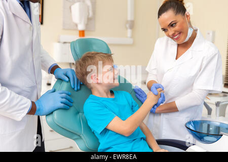 Caring femmina assistente dentale saluto poco prima del paziente checkup Foto Stock