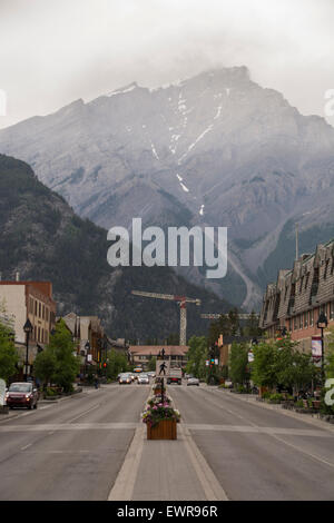 Cascade Mountain torreggiante alla fine di Banff Avenue. La più piccola Stoney Squaw Mountain coperta di alberi è proprio di fronte. Parco Nazionale di Banff, Canada Foto Stock