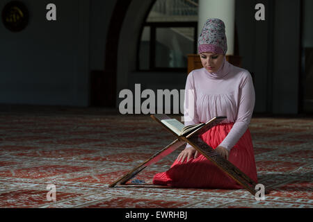 Donna musulmana la lettura di Santo libro islamico Corano Foto Stock