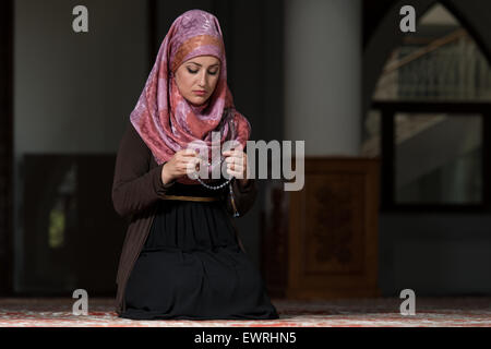 Giovane donna musulmana in preghiera nella moschea Foto Stock