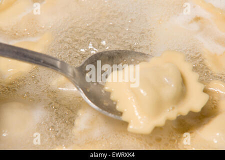 Gli gnocchi cuochi in una pentola con acqua bollente Foto Stock