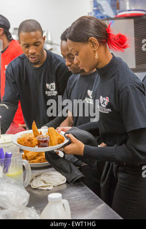 Detroit, Michigan - Cucina di lavoratori presso Kuzzo's pollo & Waffles. Foto Stock