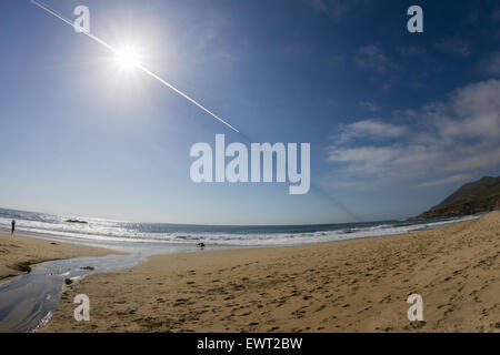 Un sentiero di strano nel cielo sopra la costa della California con un sentiero bianco dietro il piano e una linea scura davanti, girato con un Foto Stock