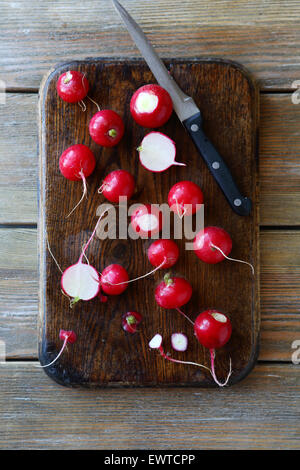 Fresche ravanelli su un tagliere e coltello Foto Stock