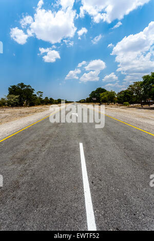 Strada infinita in Namibia, Caprivi Game Park, con cielo blu Foto Stock