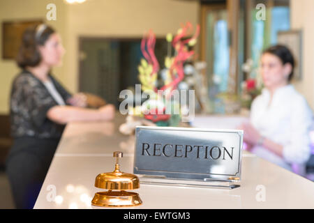 Il cliente al momento del check-in di parlare a receptionist Foto Stock