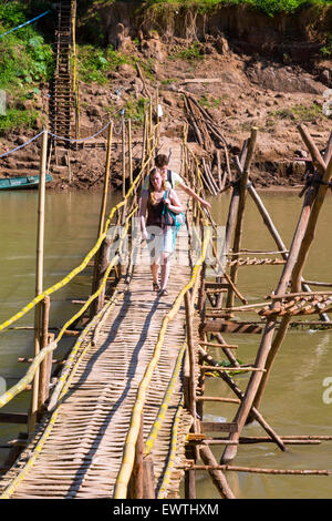 I turisti sulla passerella di bambù attraverso fiume Nam Khan, Luang Prabang, Laos Foto Stock