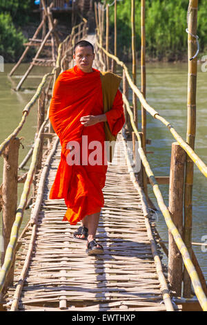 Monaco sulla passerella di bambù attraverso fiume Nam Khan, Luang Prabang, Laos Foto Stock