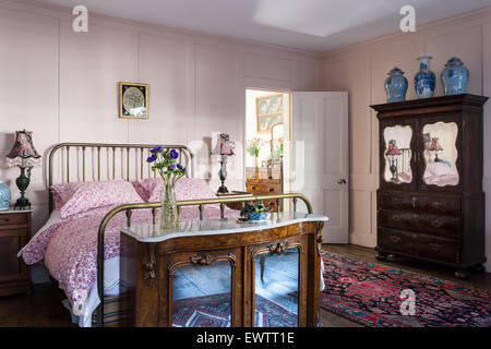 Mobili di antiquariato in una rosa la camera da letto in stile georgiano con  un raffinato specchio dorato sopra il camino Foto stock - Alamy