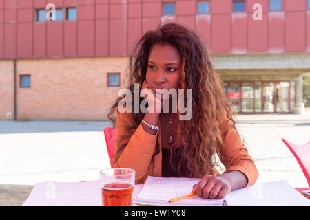 Giovane studente africano preparare gli esami presso una caffetteria locale Foto Stock