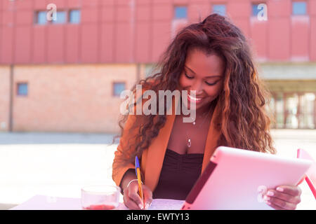 Giovane studente africano preparare gli esami presso una caffetteria locale Foto Stock