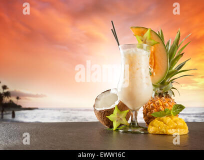 Estate esotici drink servito su pietra. Spiaggia di sfocatura sullo sfondo Foto Stock