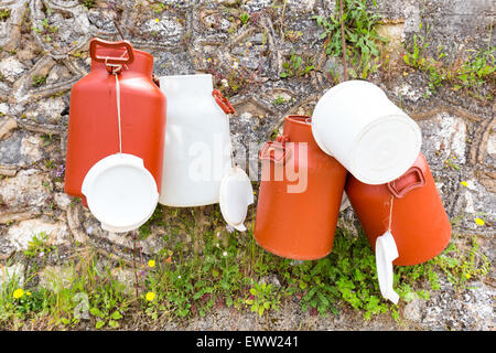 Bianco in plastica marrone e lattine di latte appesa al muro in Grecia Foto Stock