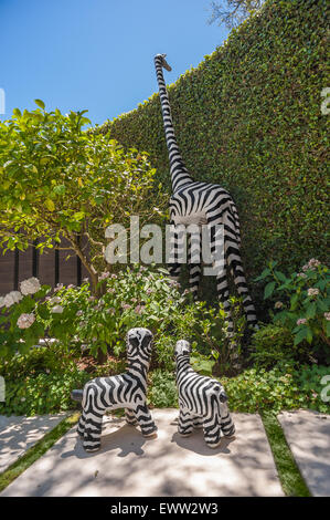 Grande e piccolo cantiere arte giraffe nel giardino sul retro Foto Stock