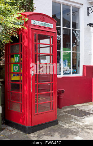 Storico telefono rosso scatola utilizzata per memorizzare un defibrillatore Foto Stock