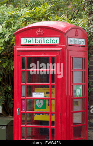 Iconico telefono rosso scatola utilizzata per memorizzare un defibrillatore Foto Stock