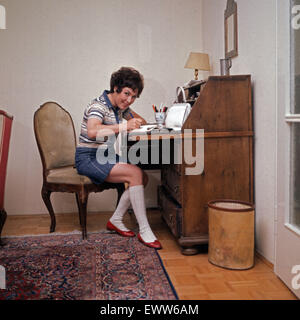 Deutsche Sängerin und Schauspielerin Monika Dahlberg am Schreibtisch, Deutschland 1960er Jahre. Il tedesco cantante e attrice Monika Dahlberg sulla sua scrivania, Germania 1960s. 6x6Dia15 Foto Stock