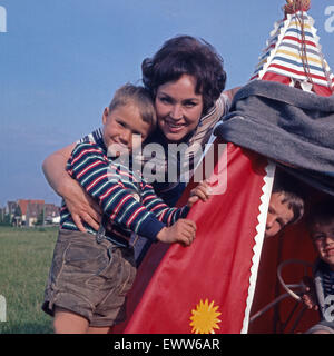 Deutsche Sängerin und Schauspielerin Monika Dahlberg spielt mit den Kindern Indianer, Deutschland 1960er Jahre. Il tedesco cantante e attrice Monika Dahlberg giocare con i bambini, Germania 1960s. 6x6Dia15 Foto Stock