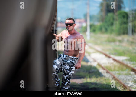 Maschio Bodybuilder tenendo premuto sul treno Foto Stock