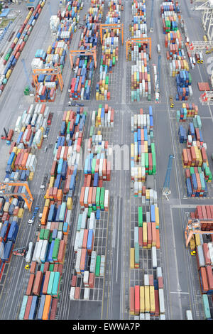 VISTA AEREA. Contenitori colorati immagazzinati temporaneamente su una banchina. Porto di Capodistria, Slovenia. Foto Stock