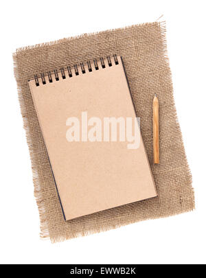 Carta marrone blocco note con matita su tela. Isolato su sfondo bianco Foto Stock