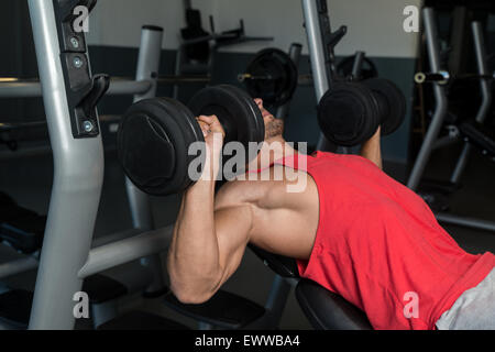 L'uomo premendo manubri Foto Stock