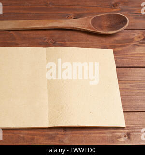 Cucchiaio di legno accanto al libro di ricette Foto Stock