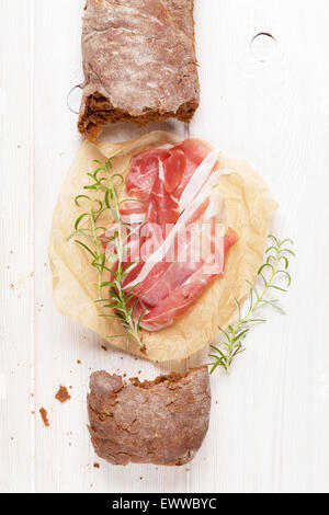 Il prosciutto italiano con la ciabatta bianca sul tavolo di legno Foto Stock